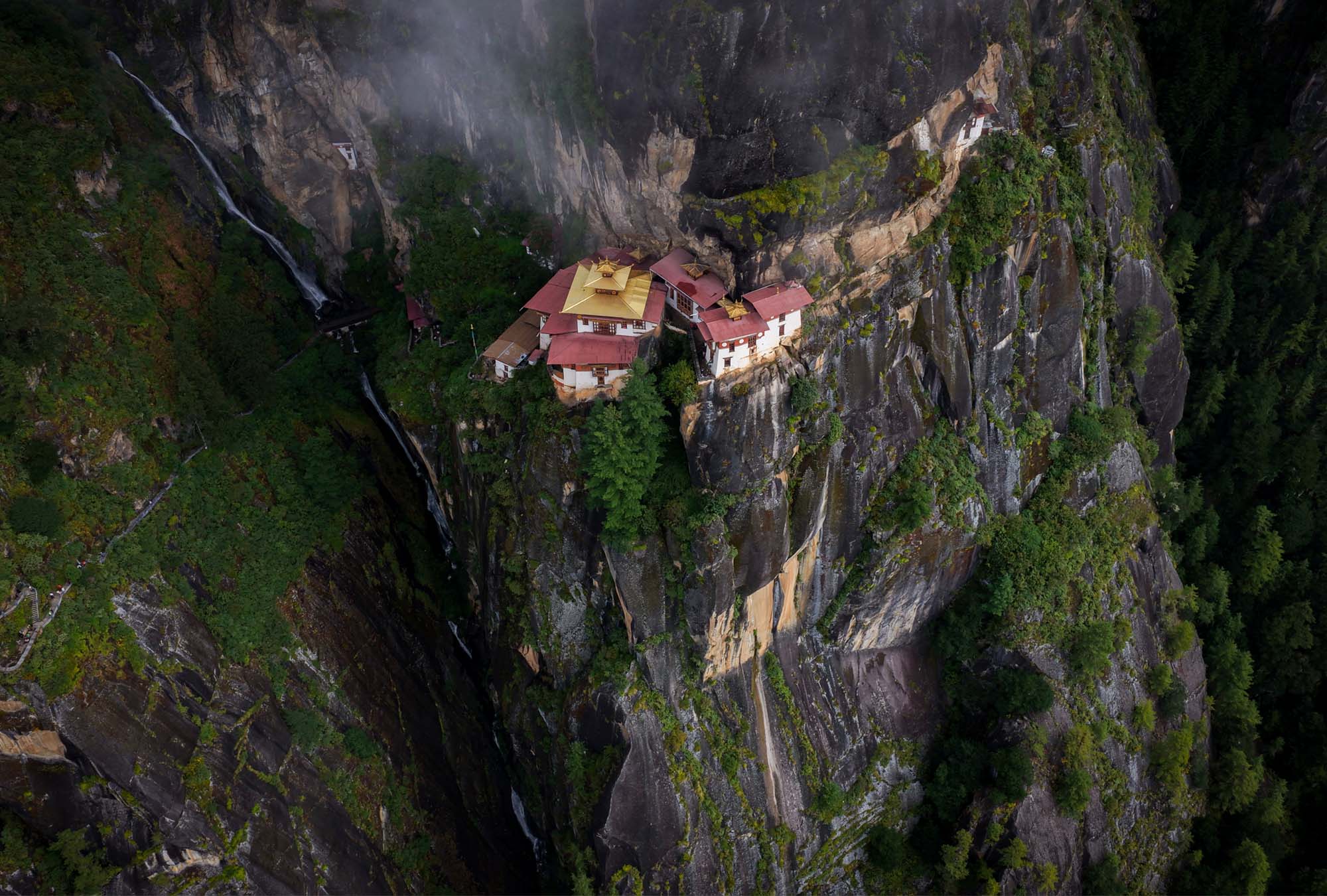 A dzong fortress-monastery perched above a Bhutanese valley
